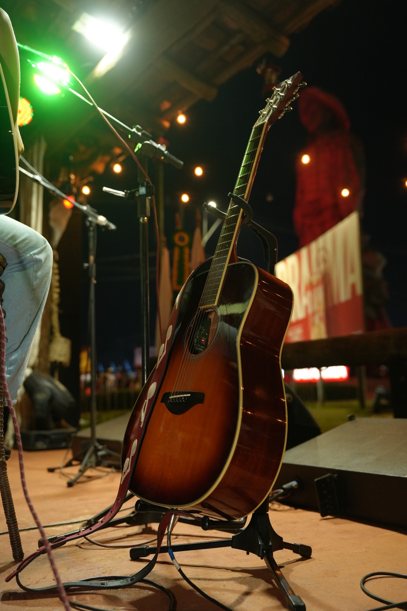 Violão no palco sob as luzes do Palco Raízes